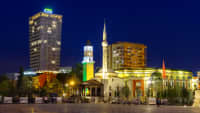 Skanderbeg Platz mit TID Tower Hotel Plaza und der Ethem Bey Moschee mit Glockenturm in Tirana, Albanien, bei Nacht