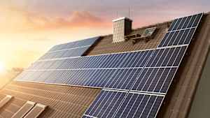 Solaranlage auf einem Hausdach bei Sonnenaufgang.