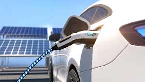 Ein Elektroauto, das an einer Ladestation durch Sonnenkilometer geladen wird, während im Hintergrund Solarzellen zu sehen sind