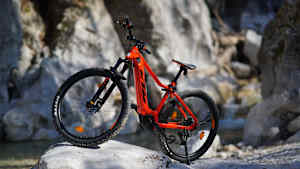 Ein rotes Fahrrad steht an einem Berg und zeigt auch beim ein e-bike gebraucht kaufen muss man keine Sorgen haben.