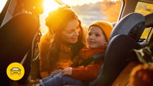 Eine Frau setzt ihren Sohn in den Kindersitz eines Autos, denn leasing funktioniert auch für Familien problemlos.