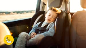 Kind schläft in Kindersitz eines Leasing-Auto während die Sonne auf ihn scheint