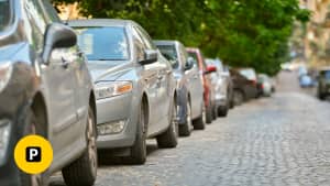 Eine Reihe von Autos parkt am Straßenrand mit einem Anwohnerparkausweis trotz Leasing