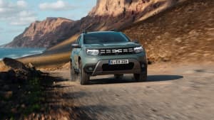 Grüner Dacia Duster fährt in Küstenlandschaft, angetrieben durch Autogas