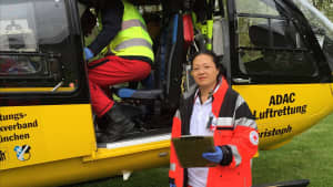 ADAC Ärztin Dr. Hui Li-Peuser steht vor einem ADAC Hubschrauber