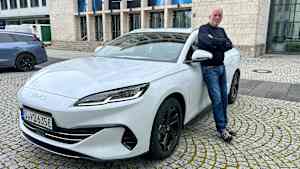ADAC Redakteur Wolfgang Rudschies lehnt an einem BYD Seal 6 DMi Touring