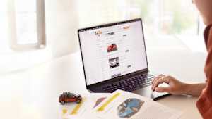 Eine Frau die an einem Laptop nach gebrauchten Elektro Autos recherchiert