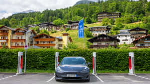 Ein grauer Tesla an einer Stromladestation vor Alpenkulisse in Berchtesgaden, Bayern