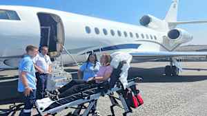 Eine Patientin auf der Trage kurz vor dem Rueckflug nach Deutschland auf dem Rollfeld