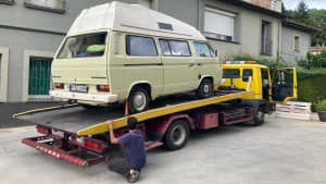 Ein grauer Bulli auf einem ADAC Abschleppwagen