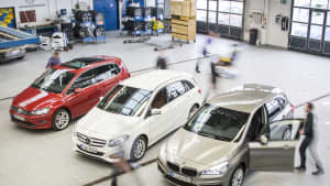 Drei Autos stehen in einer Halle