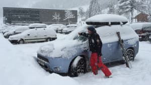 Mann befreit Auto von Schnee im Winter