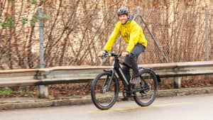 Ein Mann in gelber Jacke auf einem Speed Pedelec