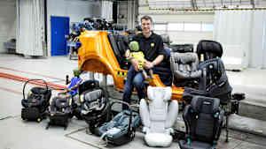 ADAC Testleiter Andreas Ratzek mit einem Kinderdummy und Kindersitzen beim ADAC Kindersitztest