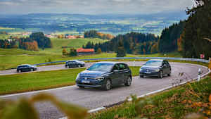 Autos fahren im Konvoi auf einer Landstraße