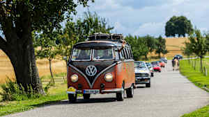 Eine Gruppe von Oldtimern fährt auf einer Landstraße
