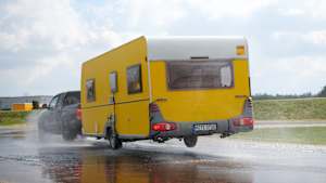 Das Rad eines Wohnwagens löst sich beim Reifentest für Anhänger von der Fahrbahn
