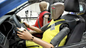 Zwei Dummies sitzen im Auto für den Crashtest Rückhaltesysteme
