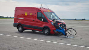 Ein Transporter fährt auf einen Fahrradfahrerdummy zu
