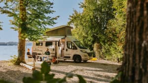 Ein Pärchen sitzt vor seinem Wohnmobil am Campingplatz Ambach