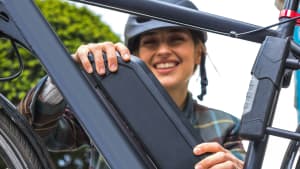 Eine Frau wechselt den Akku ihres E-Bikes