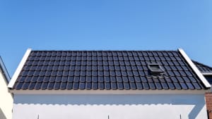 Ein Einfamilienhaus mit Solardachziegeln bestückt