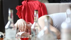 Ein Mann liegt nach zu viel Alkoholkonsum reglos auf dem Sofa