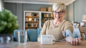 Eine Frau misst ihren Blutdruck Zuhause