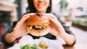 Eine Frau die einen Burger isst