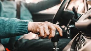 Ein älterer Mann sitzt am Steuer eines Autos