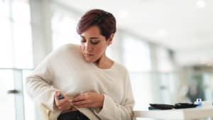 Eine junge Frau verabreicht sich in einem öffentlichen Raum eine Diabetes Spritze