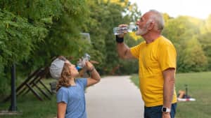 Ein alter Mann und ein kleiner Junge trinken Wasser