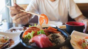 Mann isst Sashimi