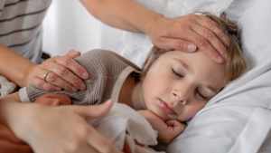 Ein krankes Kind liegt mit Fieber im Bett