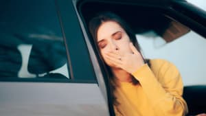 Frau steigt aus dem Auto und leidet unter Reisekrankheit.
