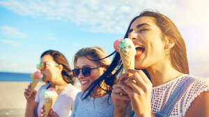 Drei junge Frauen essen Eis am Meer