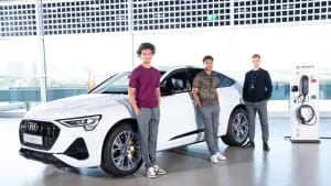 Leroy Sané, Serge Gnabry, Joshua Kimmich stehen vor einem Audi E-Tron