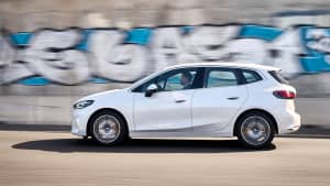 Die Seitenansicht eines weißen fahrenden BMW 2er Active Tourer