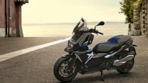Der BMW C 400 X Scooter an einem See auf Kopfsteinpflaster