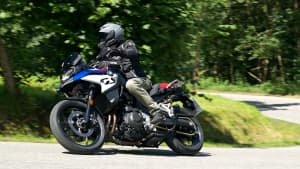 Aufnahme der seitlich fahrenden BMW F 800 GS in einem Wald