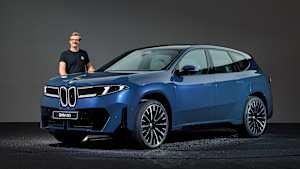 ADAC Redakteur Andreas Huber steht hinter einem BMW iX3