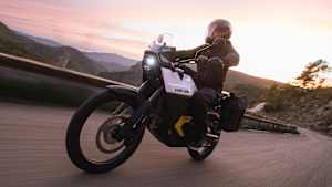 Ein Can Am Origin Elektromotorrad fährt eine kurvige Strecke bei Sonnenuntergang