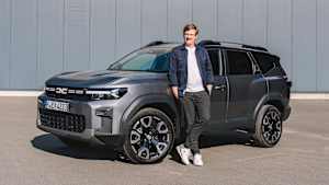 ADAC Redakteur Andreas Huber steht neben einem Dacia Bigster