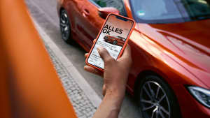 Ein Frau öffnet die Daten Ihres Auto über die Remote App am Handy