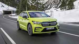 Front und Seitenansicht eines fahrenden Skoda Enyaq in einer Winterlandschaft