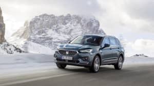 grauer Seat Tarraco faehrt auf Strasse durch Winterlandschaft