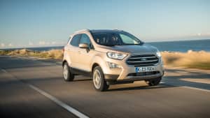 beigener Ford EcoSport faehrt Kuestenstrasse entlang