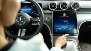 Eine Frau sitzt im Auto und nutzt nach dem Tanken das InCarPayment System