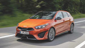 Ein organgefarbener KIA Ceed GT während der Fahrt von vorne