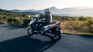 Eine Kymco AK 550i ABS Premium fahrend auf einer Straße